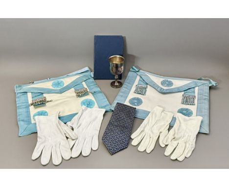 Two Master Mason's Freemasons aprons - together with gloves, a Masonic tie; a ritual book; and a silver plated goblet.
