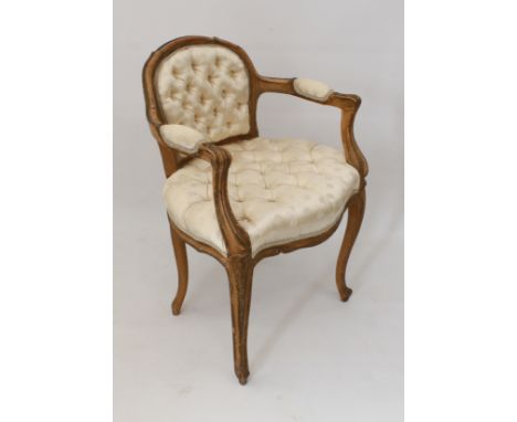 A carved beech-wood low-back fauteuil in 18th century French style&nbsp;- late 19th or early 20th century, with buttoned ivor