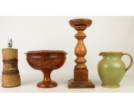 Four pieces: 1. a turned burr wood pedestal bowl, 21.5 cm high 2. a turned wooden church-style candlestick, 41.5 cm high 3. a