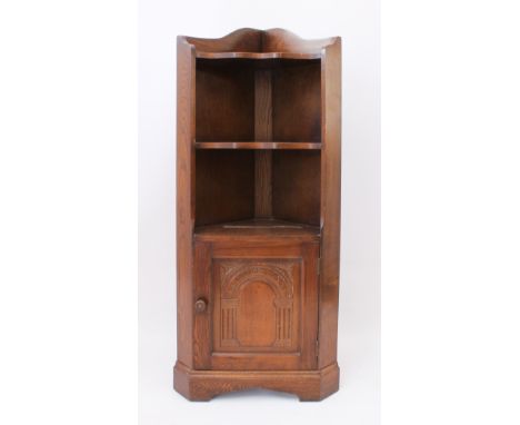 A reproduction oak corner cupboard - late 20th century, sloping gallery back over two waved shelves, single cupboard door wit