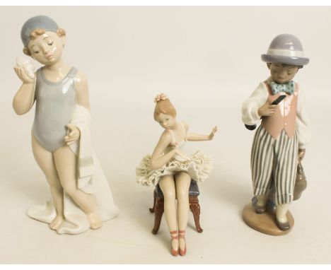 Two Lladro and one Nao figurine - a seated ballerina (15.5 cm high), a boy musician with clarinet and valise (22 cm high), a 