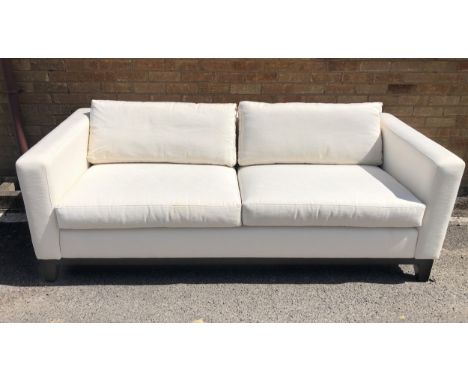A large, cream two seater sofa with extra loose cover