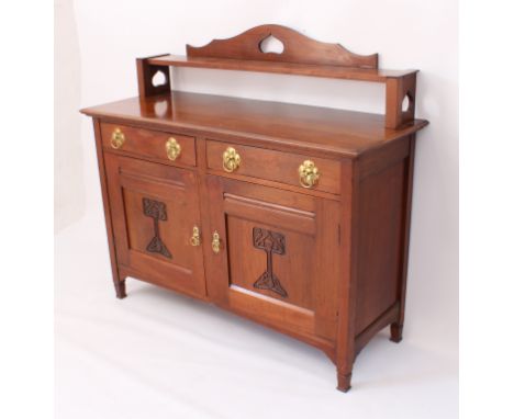 A Liberty-style Arts &amp; Crafts walnut sideboard - the moulded top with raised rear shelf with heart-pierced supports and a