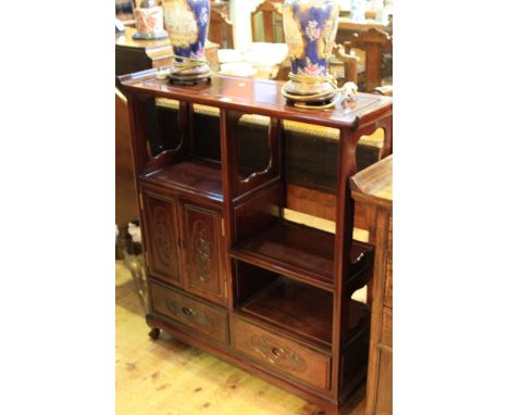 Oriental redwood cabinet having three open compartments and two carved panel doors above two drawers