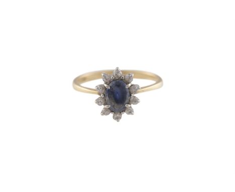 A SAPPHIRE AND DIAMOND CLUSTER RING, the oval-shaped sapphire within a surround of old brilliant-cut diamonds, mounted in 18K
