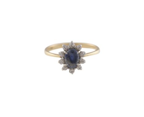 A SAPPHIRE AND DIAMOND CLUSTER RING, the oval-shaped sapphire within a surround of old brilliant-cut diamonds, mounted in 18K