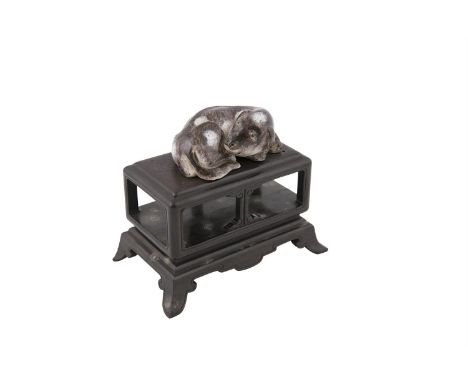 A CHINESE AUBERGINE GLAZED MODEL OF A RECUMBENT HOUND, 18th/19th century, modelled in curled position, the base with cursive 