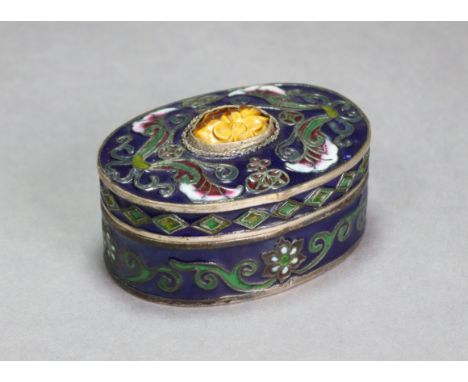 A Chinese enamelled metal oval box &amp; cover, inset carved tiger’s-eye floral cabochon, &amp; with all-over foliate scroll 