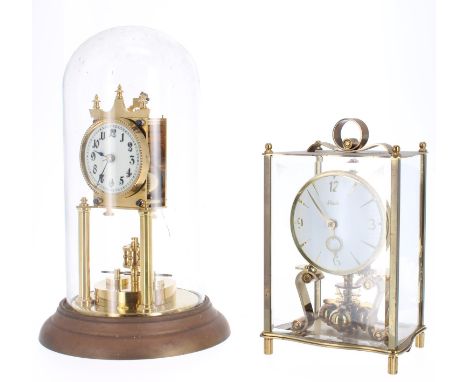 Brass torsion mantel clock, the 2.75" white dial over a disc pendulum, under a glass dome and upon a circular stepped base, 1