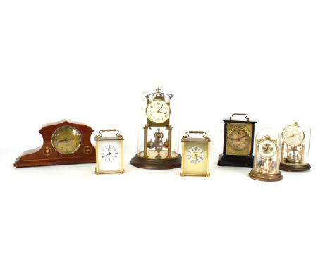 Brass torsion clock, under a glass dome and upon a stepped circular base, 11" high; also two miniature brass torsion clocks u