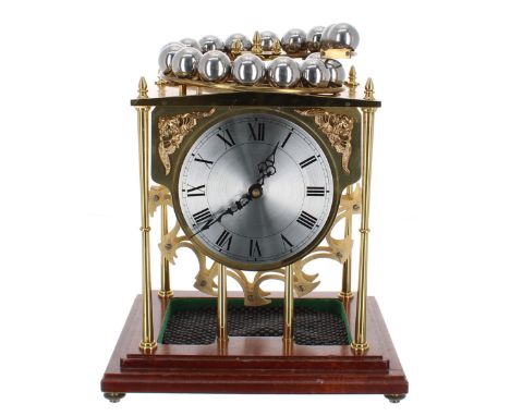 Good reproduction brass novelty clock, the movement with platform escapement powered by ball bearings falling from a track fi