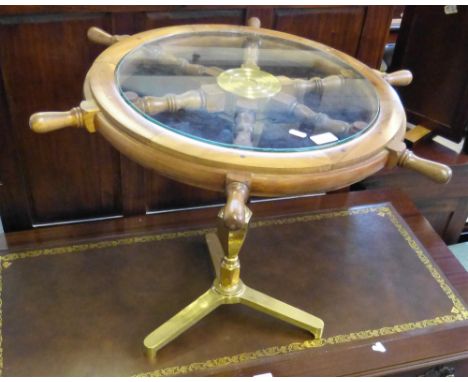 A novelty occasional table formed from a teak ships wheel with glass top and brass pedestal tripod base 72cm diameter