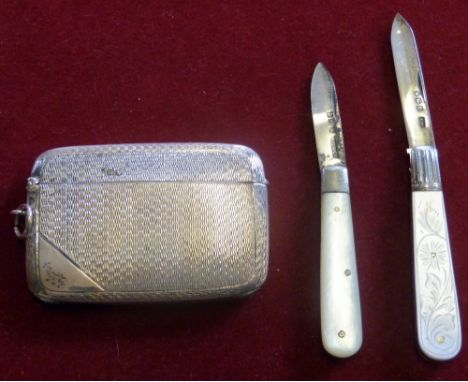 A silver vesta case Chester 1922 with engine turned decoration and two silver bladed mother of pearl fruit knives.