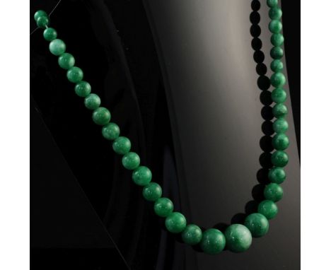A single strand graduated jade bead necklace, 19in. A single strand graduated jade bead necklace, with yellow metal clasp, 19
