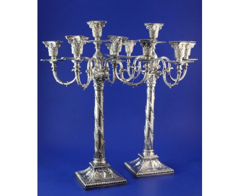 A harlequin pair of Edwardian silver corinthian column five light four branch candelabra, weighted. A harlequin pair of Edwar