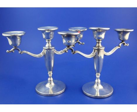A pair of 1950's silver two branch three light candelabra, weighted. A pair of 1950's silver two branch three light candelabr