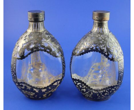 A pair of late 19th/early 20th century Chinese silver overlaid dimpled moulded glass decanters and lids, 8in. A pair of late 