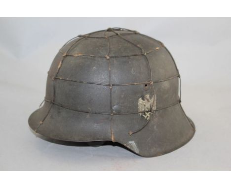 A German Third Reich M42 army helmet, A German Third Reich M42 army helmet, with single decal and camouflage wire, with leath