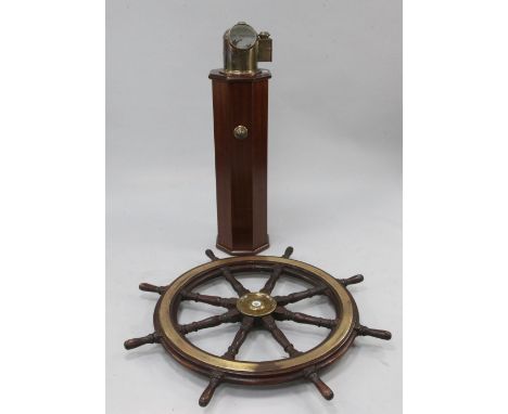 A teak eight spoke ship's wheel on an octagonal mahogany column, 43.5in. A teak eight spoke ship's wheel on an octagonal maho