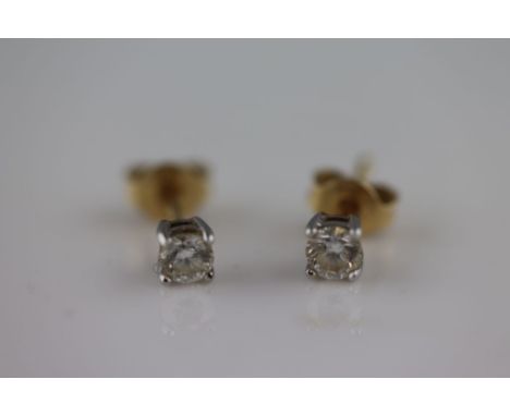 A pair of diamond solitaire 18ct yellow gold and white gold set earrings, the round brilliant cut diamonds having stated weig