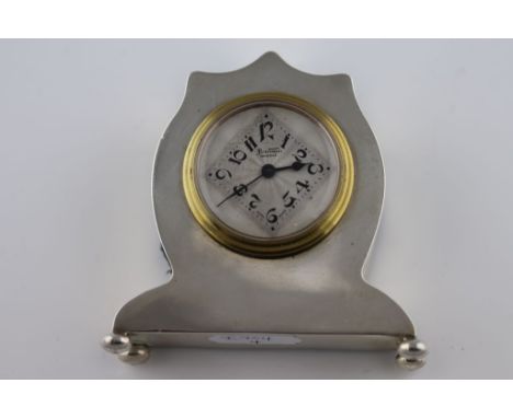 An Art Deco silver Bentina travel clock in the form of a shield mantel clock on four ball feet, silvered engine turned dial, 