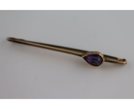 An Edwardian amethyst 9ct yellow gold bar brooch, the rub over set pear shaped mixed cut amethyst measuring approximately 7mm