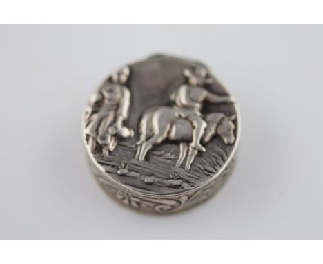 An Edwardian silver circular patch box, repousse rustic country scene to lid of rider on horse asking country girl for direct