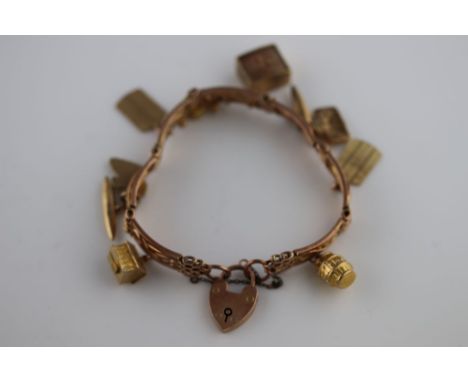 A 9ct rose gold fancy gate link padlock clasp charm bracelet comprising seven curved figure of eight gate link panels and ten