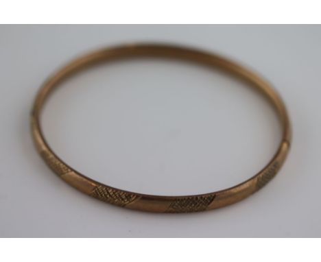 A 9ct rose gold bangle, textured engraved decoration, band width approximately 5mm