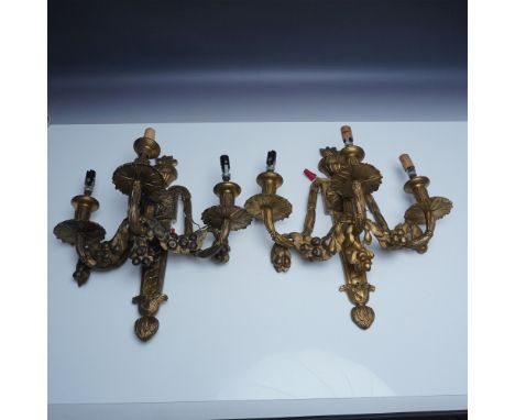 This pair of exquisite antique gilt bronze three-arm wall sconces showcases intricate floral and foliate motifs, embodying th