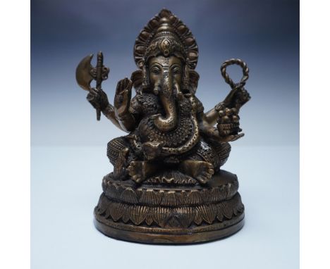 This finely crafted bronze statue depicts Ganesha, the Hindu deity of wisdom and prosperity, seated on a tiered lotus base. T