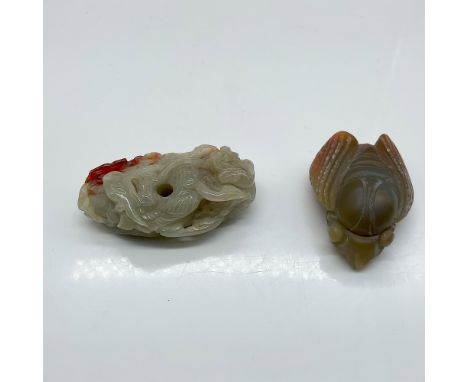 A finely carved pair of Chinese toggles, one crafted from jade and the other from agate. The jade toggle features an intricat