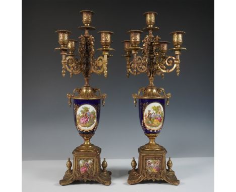 A finely crafted Italian gilded brass candelabras, featuring an ornate Rococo-style design each with five candle-holders ador