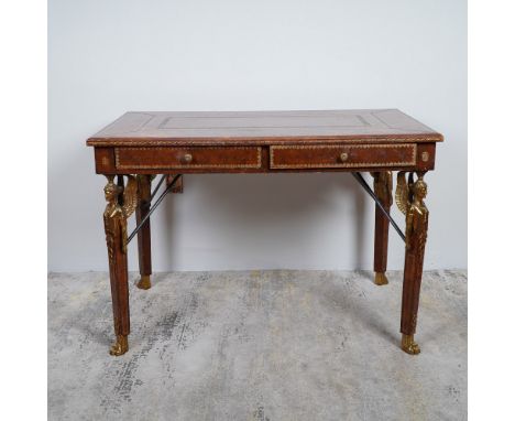A refined French Empire-style writing desk featuring a rich tooled leather top with gold-embossed detailing, framed by a wood