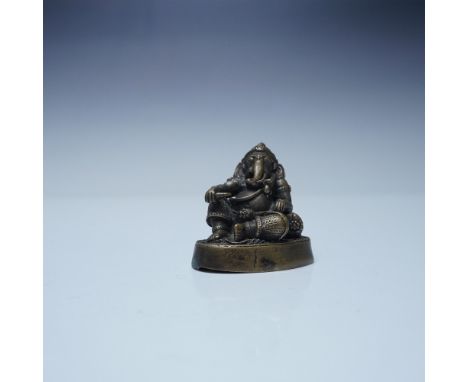 A finely detailed bronze figurine of Ganesha in a reclining posture, symbolizing wisdom and prosperity. Featuring intricate a