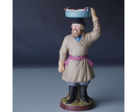 This finely detailed figurine by the Gardner Porcelain Factory of Russia portrays a fish vendor carrying a large blue basin f