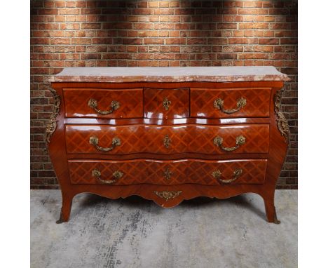 A stunning French Louis XV style bombe commode, featuring a serpentine front with a beautifully faux marquetry veneer in a ge