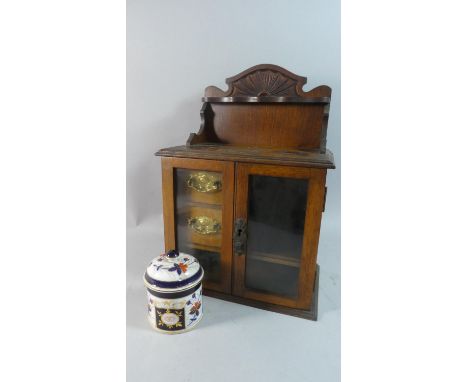 An Edwardian Oak Smokers Cabinet with Imari Patterned Ceramic Tobacco Pot and Silver Plated Presentation Label to S Hardwick,