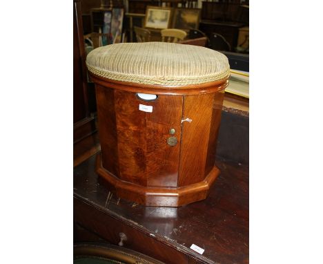 Walnut commode, the upholstered oval seat lifting to reveal interior chamber pot, the dodeconal base with hinged compartment