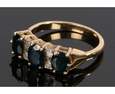 18 carat gold sapphire set ring, with three oval sapphires and four round cut stones to the head, ring size M