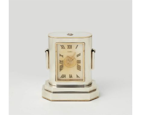 Cartier Art Déco-TischuhrWeißmetall. Auf gestuftem oktogonalem Sockel silberfarbener, partiell gold konturierter Korpus in ab