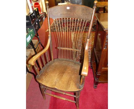 An early 20th century oak comb back armchair, raised on spindle turned stretchers, width 60cm