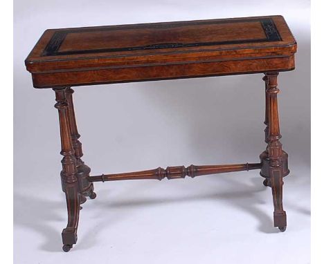 A Victorian Aesthetic Movement figured walnut and ebonised card table, the fold-over top with swivel action, opening to revea