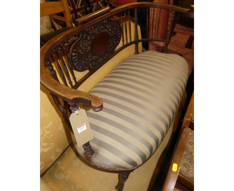 A circa 1900 mahogany spindle back two-seater salon sofa, having floral pierced back panel, striped upholstered stuff over se