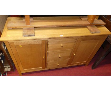 A contemporary light oak sideboard, having three central drawers flanked by cupboard doors, width 133cmCondition report: Widt