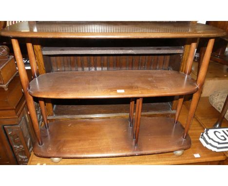 An Ercol dark elm three-tier book trolley, raised on roller castors, w.91cmCondition report: Condition is good, lots of light