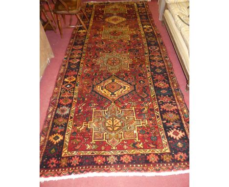 A Persian Heriz red ground hall runner, 338 x 140cmCondition report: Some light nibbling to edges.  Colours are good to satis