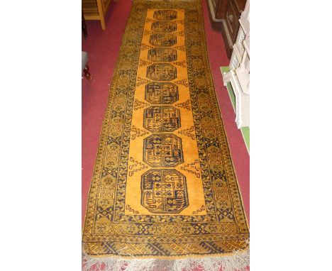 A Persian woollen orange ground Bokhara hall runner, 324 x 95cm
