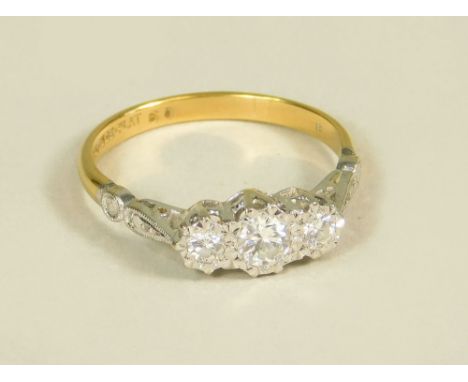 DIAMOND RING. An 18ct. gold &amp; platinum illusion set three stone diamond ring. Size O.