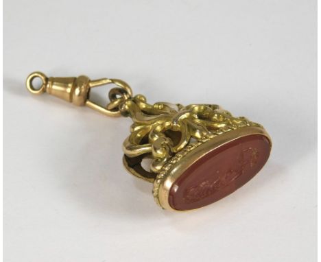 WATCH FOB. A 19th century gilt metal watch fob, set with a cornelian intaglio with a classical figure.
